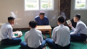 Seorang guru dengan teliti menyimak setoran hafalan santri dalam program tahfidz unggulan Jabal Rahmah Mulia